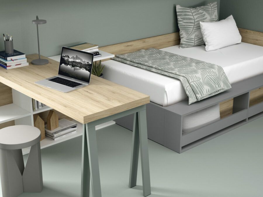 mesa de escritorio junto a una cama